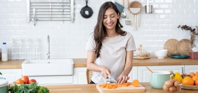 Woman in the kitchen chopping some vegetables